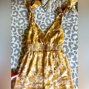 Floral yellow jumpsuit with a boot cut flare bottom.